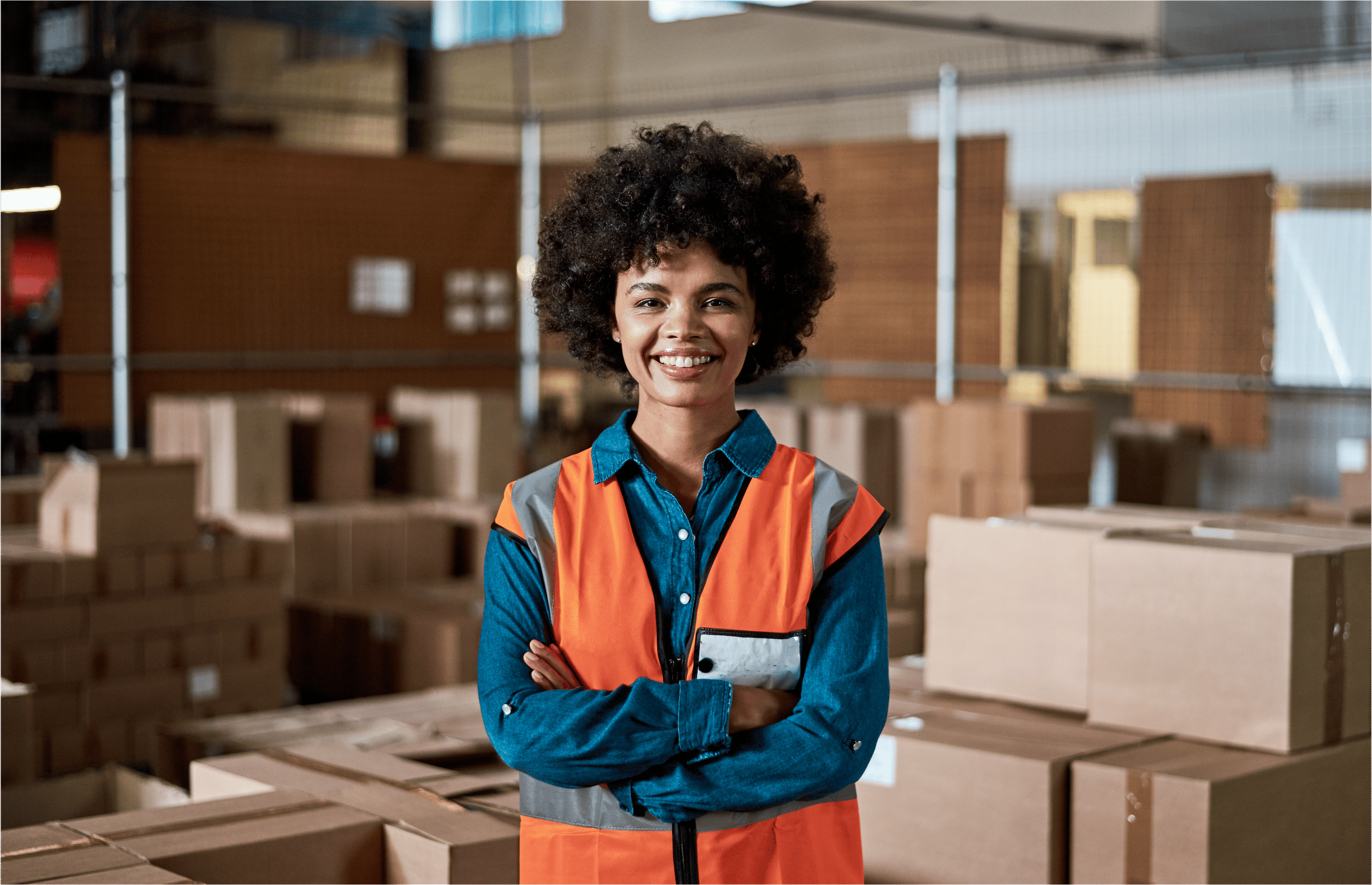 A woman in an orange safety vest is looking at us and smiling.